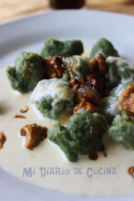 Ñoquis de espinacas, con salsa de queso y nueces caramelizadas